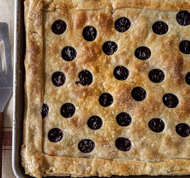 A Cranberry Sauce Slab Pie baked in a large baking sheet and decorated with a cut-out crust.