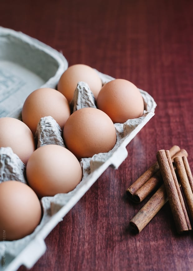 A carton of eggs on a wooden background.