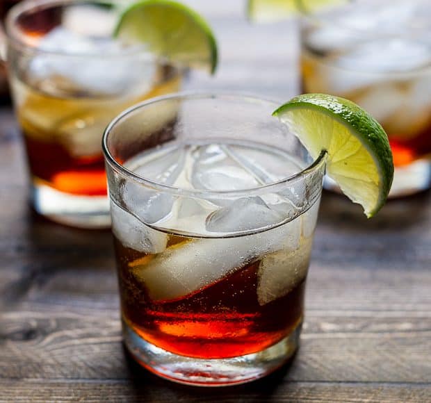 A Pumpkin Spice Dark and Stormy Cocktail on a wooden surface.