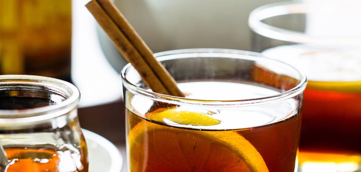 Chai Hot Toddy garnished with lemon slices and cinnamon sticks.