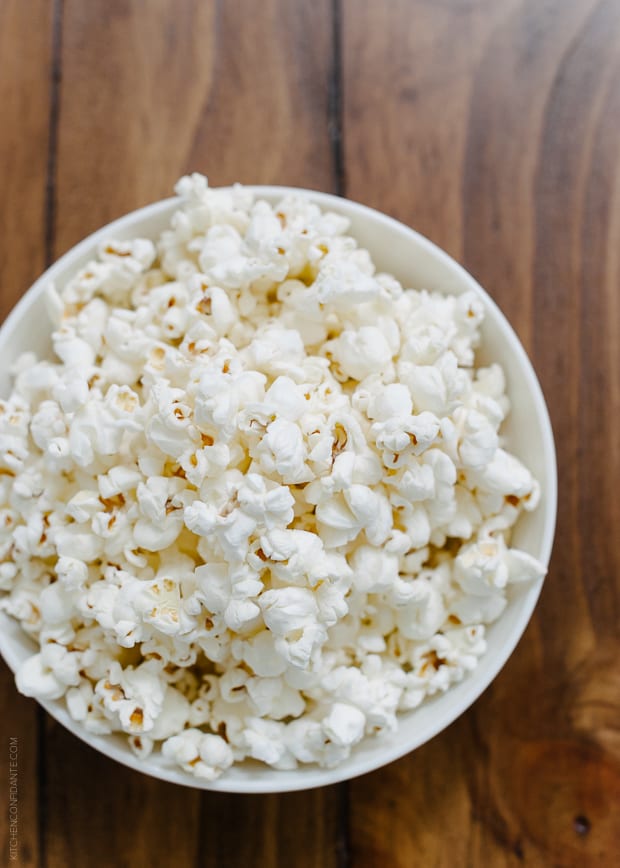 A bowl of popcorn on a wooden surface.