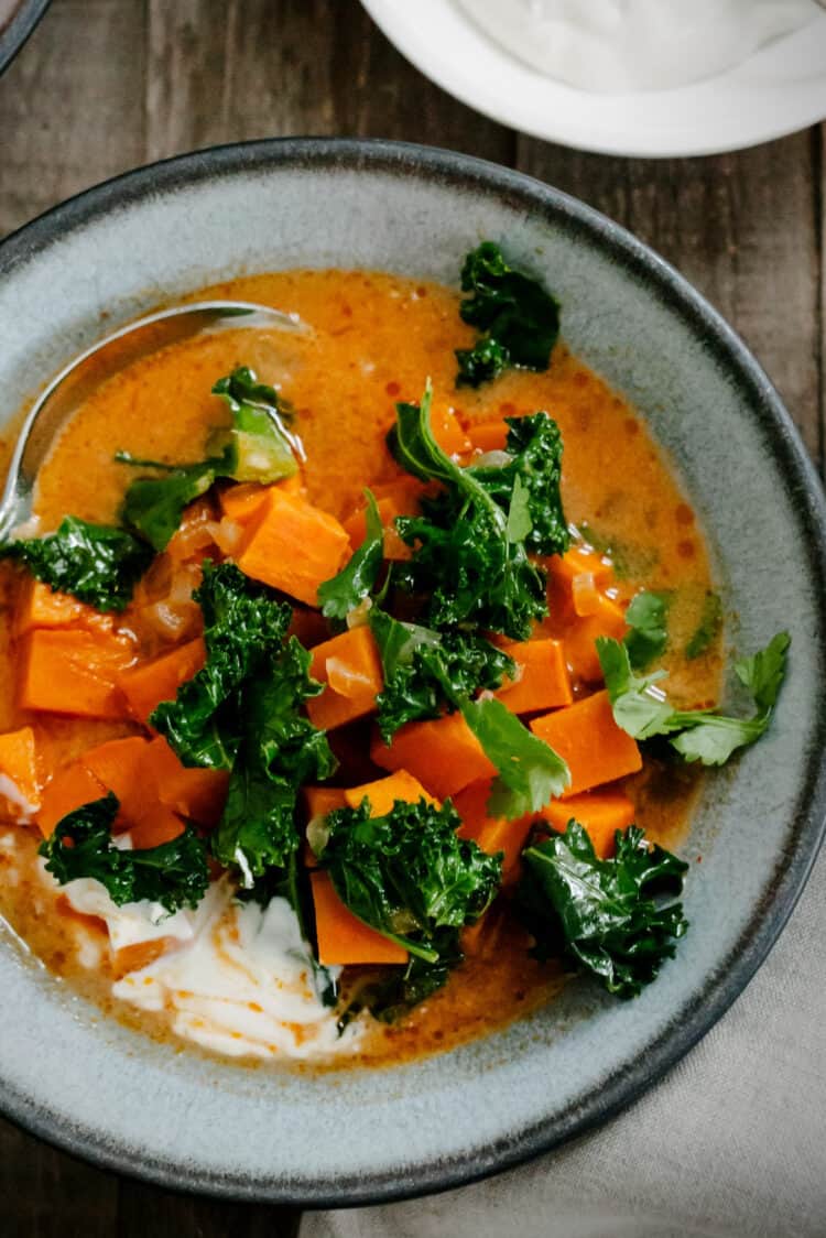 Sweet Potato and Kale Coconut Curry Soup in a grey bowl