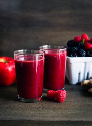 Soothing Hot Apple Berry Ginger Juice in glasses with fresh berries, apple and ginger.