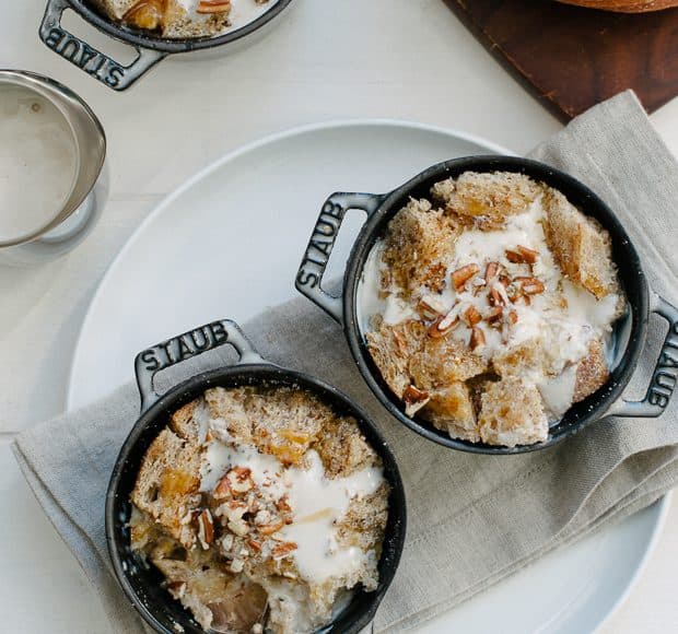 Miniature Dutch Oven pans filled with Irish Cream Sourdough Bread Pudding and topped with a drizzle of Irish Cream.
