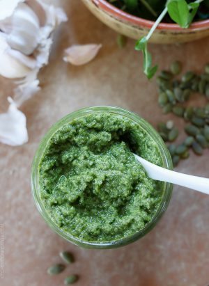 A glass jar filled with homemade Pea Shoot and Pumpkin Seed Pesto.