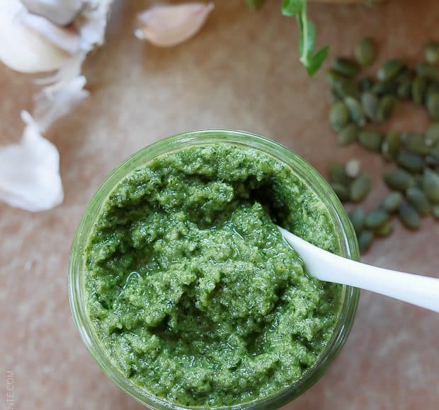 A glass jar filled with homemade Pea Shoot and Pumpkin Seed Pesto.