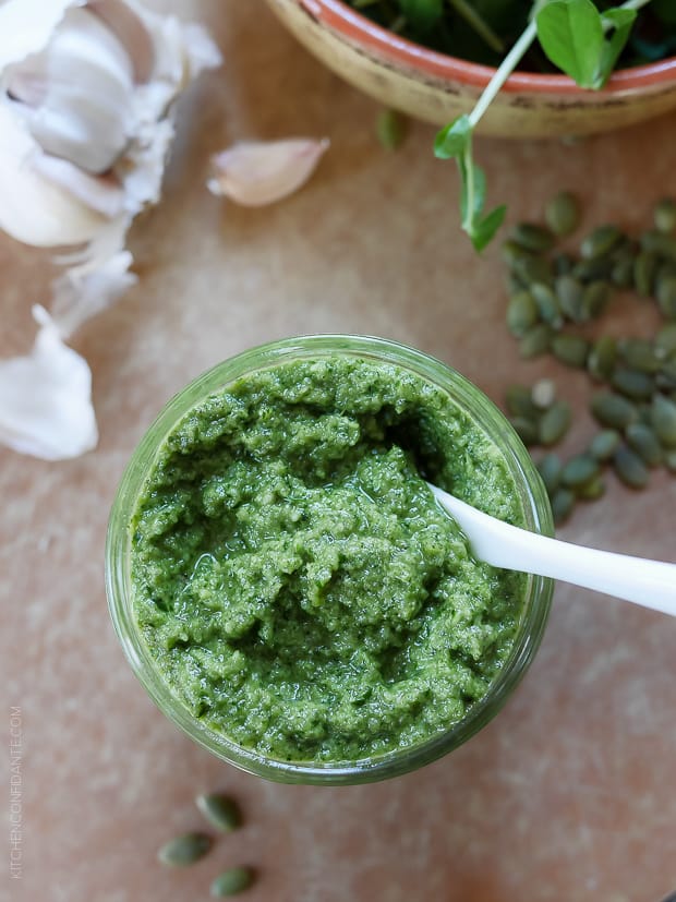 A glass jar filled with homemade Pea Shoot and Pumpkin Seed Pesto.