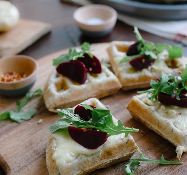 Waffle Pizzas with Roasted Garlic, Beets and Brie on a wooden serving board.