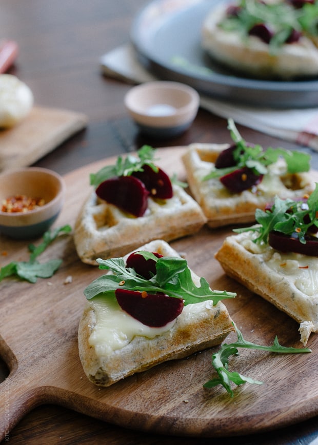 Waffle Pizzas with Roasted Garlic, Beets and Brie on a wooden serving board.