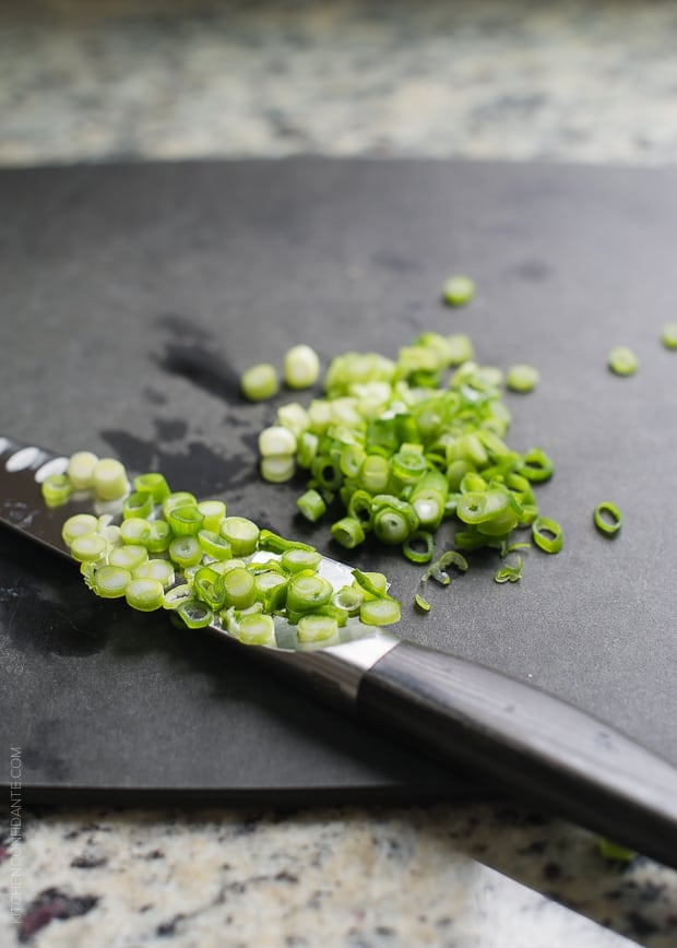 Chopped green onions on a cutting board.