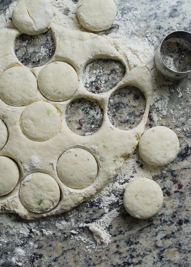 Boursin Garlic and Herb Buttermilk Biscuits cut out on a granite surface.