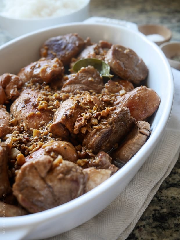 A white serving dish filled with Filipino Chicken and Pork Adobo.
