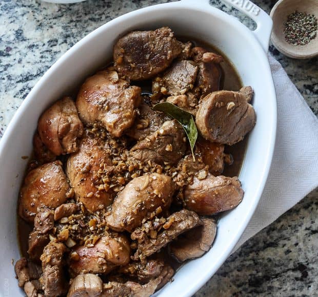 A white serving dish filled with Filipino Chicken and Pork Adobo.