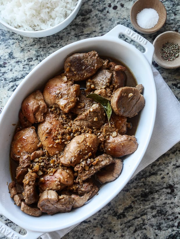A white serving dish filled with Filipino Chicken and Pork Adobo.