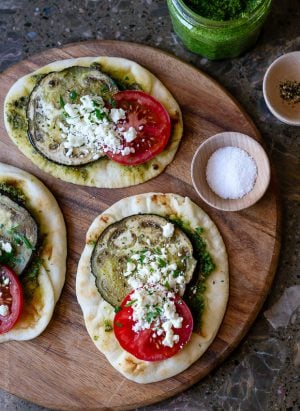 Roasted Eggplant, Tomato and Pesto Mini Naan on a wooden serving board.