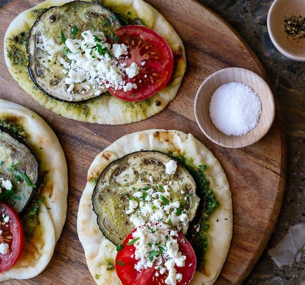 Roasted Eggplant, Tomato and Pesto Mini Naan on a wooden serving board.