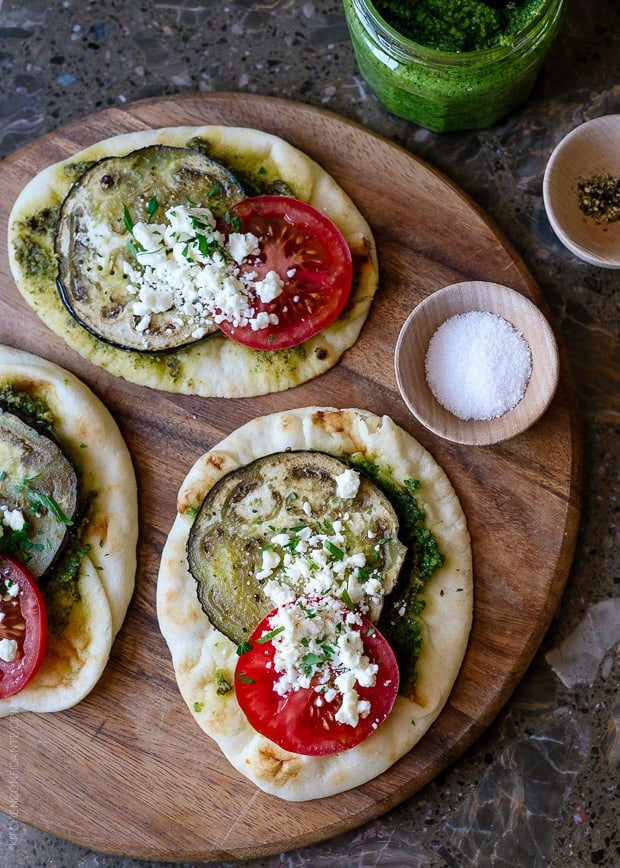 Roasted Eggplant, Tomato and Pesto Mini Naan on a wooden serving board.