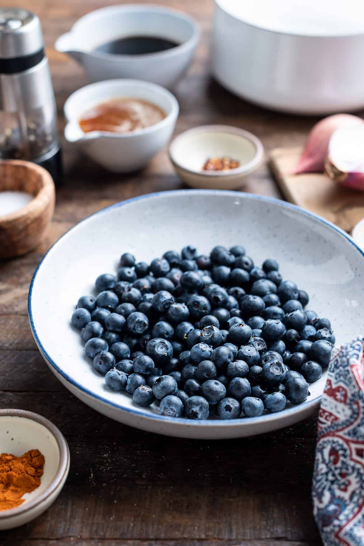 A white dish filled with fresh blueberries. 