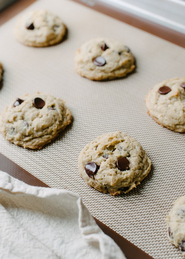 Chocolate Chip Cookies on a brown silpat-lined baking sheet.