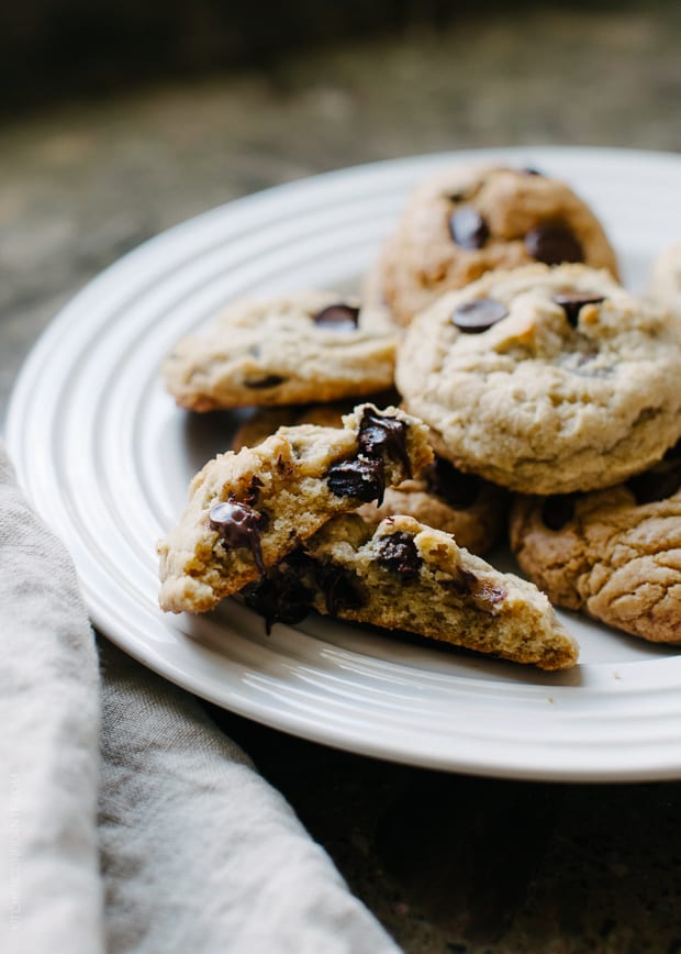 Gooey chocolate chip cookies on a white plate.