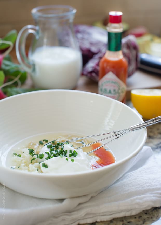 Tabasco and other ingredients in a white bowl ready to stir together a buttermilk dressing.