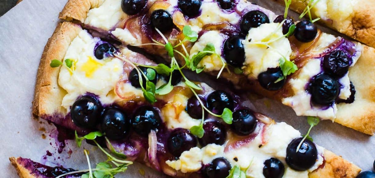Blueberry, Feta and Honey-Caramelized Onion Naan Pizza on a cutting board.