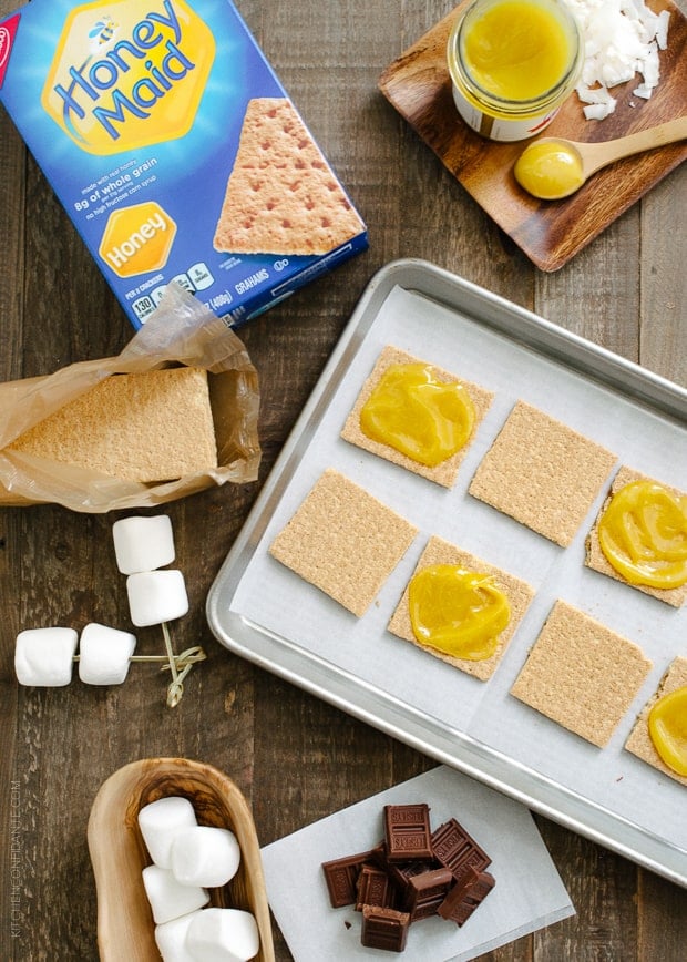 Graham crackers spread with coconut jam on a sheet pan.