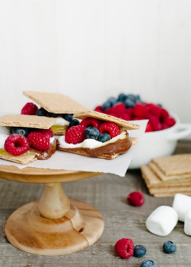 Homemade s'mores arranged on a wooden cake stand.