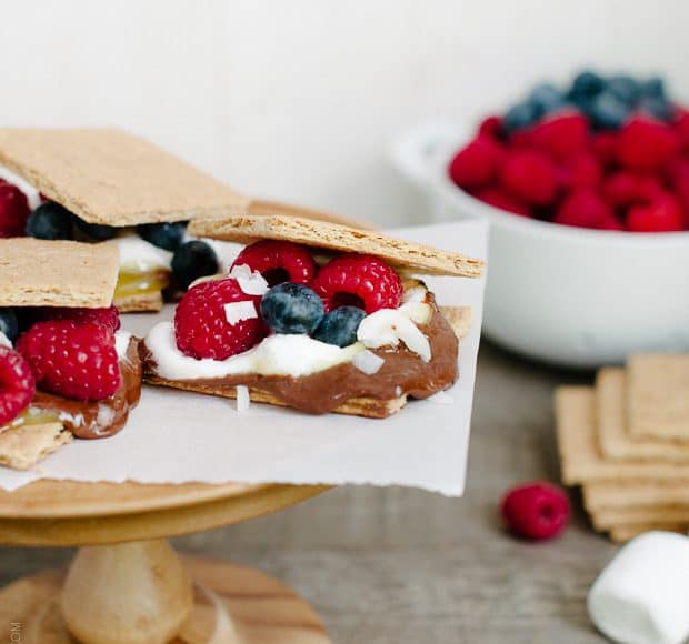 Coconut Jam Berry S'mores arranged on a wooden cake stand.