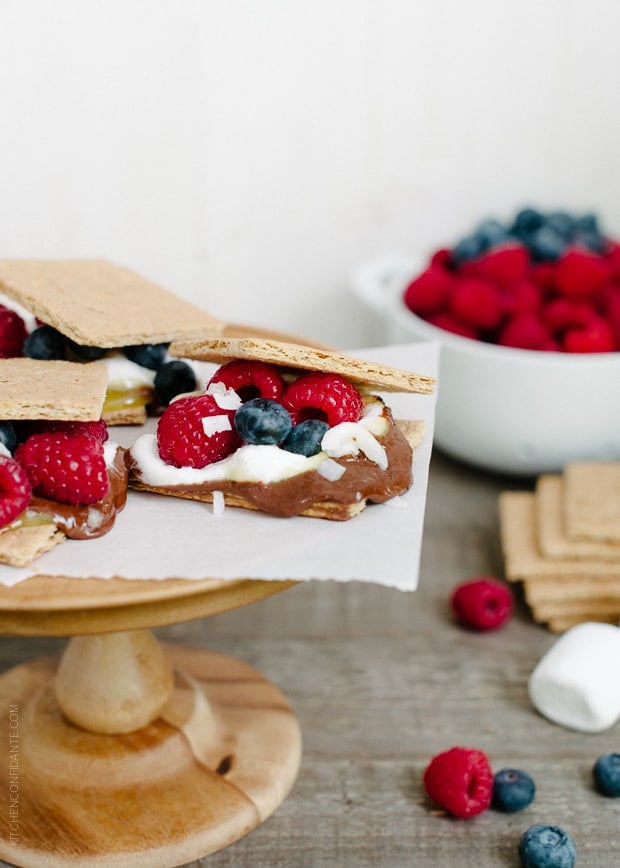 Coconut Jam Berry S'mores arranged on a wooden cake stand.