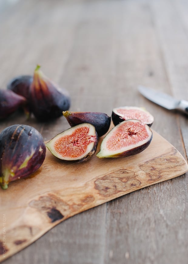 Fresh summer figs sliced on a wooden serving board.