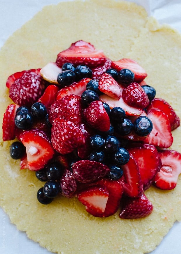 Filling a galette crust with mixed berries. 