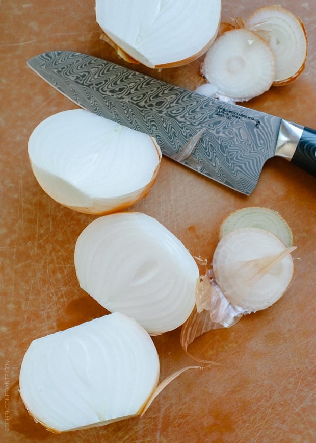 Halved onions on a wooden surface.