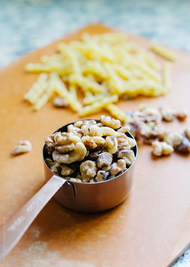 Walnuts in a metal measuring cup.