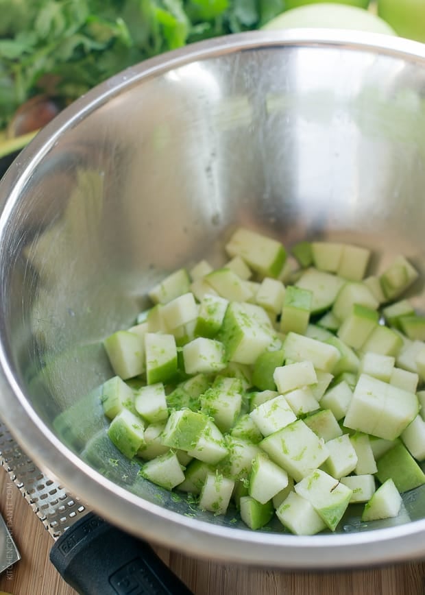 Chopped green apples in a metal bowl.