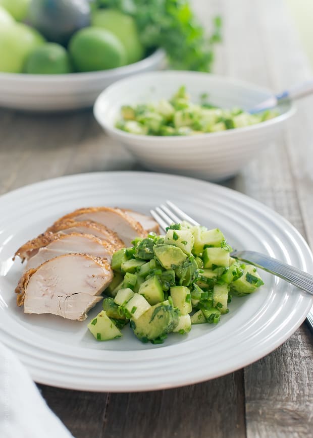 Green Apple Salsa Verde alongside sliced chicken on a white plate.