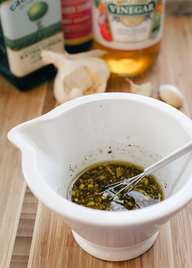 Whisking a marinade in a small white bowl.