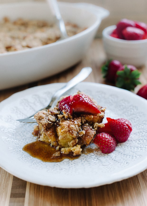 A piece of Baked Buttermilk French Toast with Oat Streusel topped with strawberries.