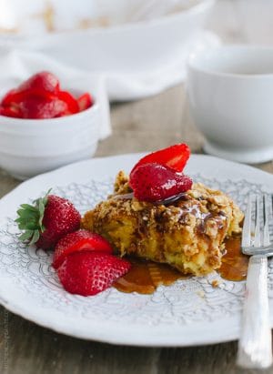 A piece of Baked Buttermilk French Toast with Oat Streusel topped with strawberries.