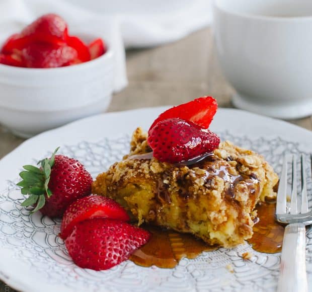 A piece of Baked Buttermilk French Toast with Oat Streusel topped with strawberries.