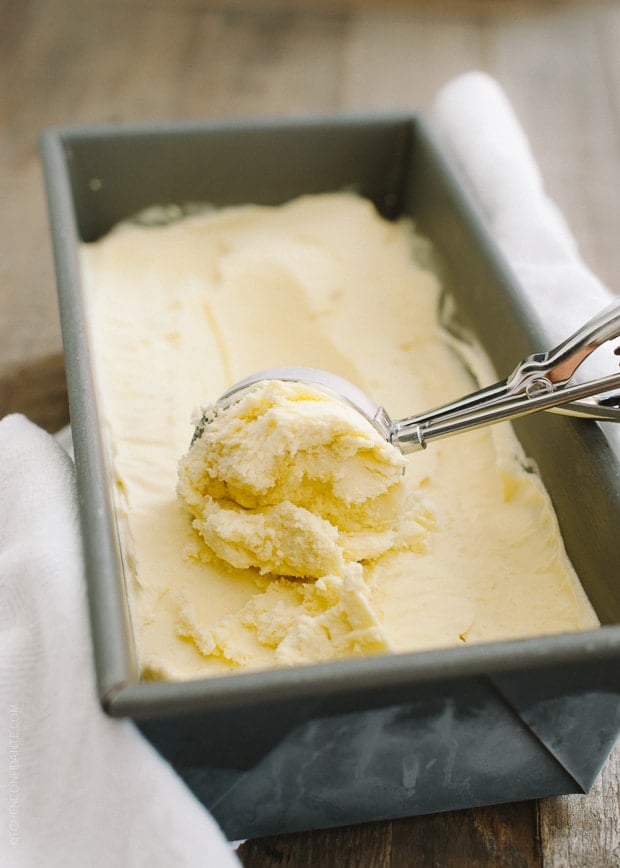 Scooping fresh homemade Dairy Free Mango Coconut Ice Cream out of a loaf pan where it was frozen.