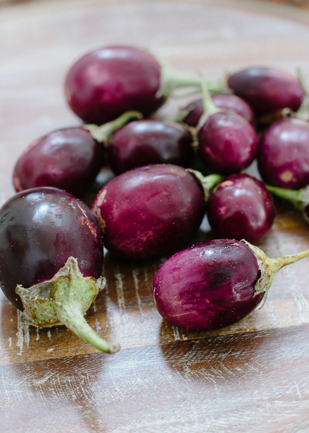 Purple eggplants on a wooden surface.