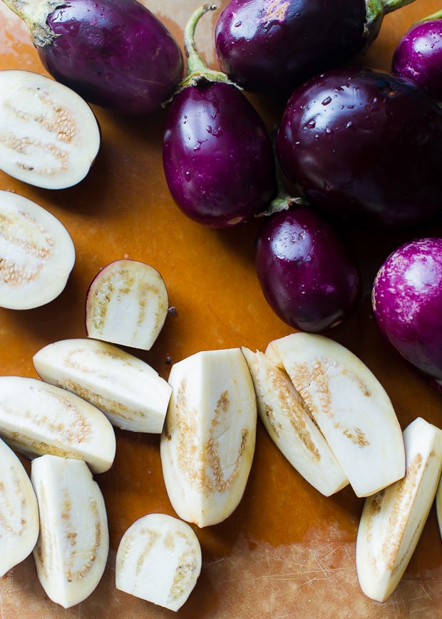 Eggplants sliced open on a cutting board.