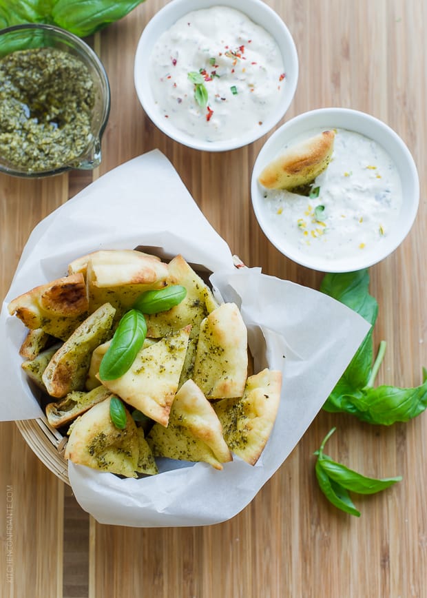 Basket of Pesto Baked Naan Chips with fresh basil garnish and served with dip.