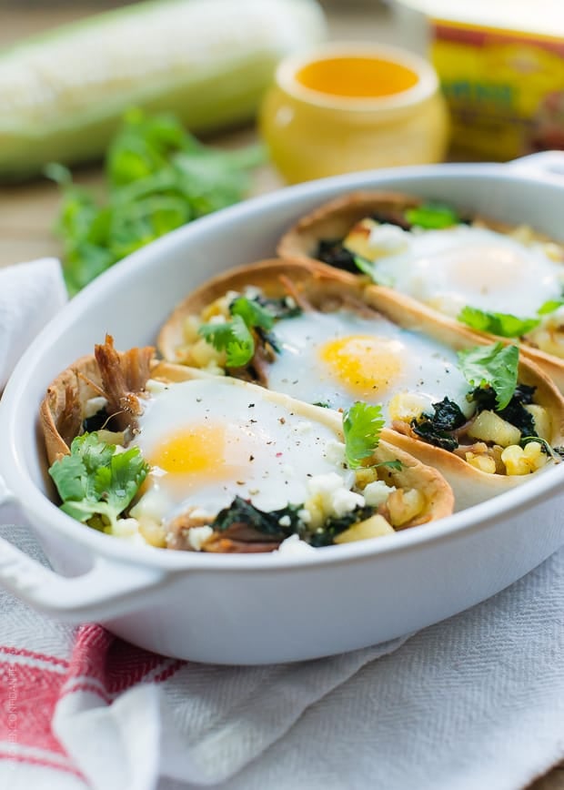 Eggs baked into tortilla shells filled with shredded pork, potatoes, and kale to make weeknight taco boats.