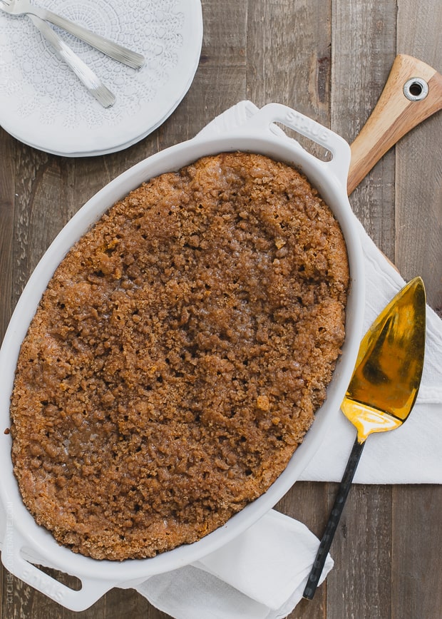 Buttered Rum and Candied Sweet Potato Crumb Cake baked in a white oval dish.