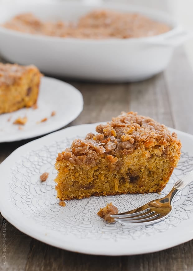 Slice of Buttered Rum and Candied Sweet Potato Crumb Cake on a white plate.