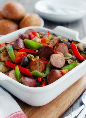 An 8x8 casserole dish filled with chopped sausage, eggplant, and peppers.