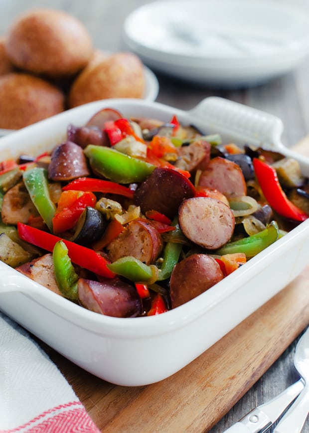 An 8x8 casserole dish filled with chopped sausage, eggplant, and peppers.