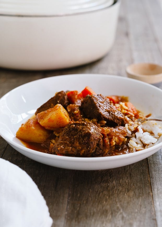 Mechado - Filipino Beef Stew with beef and potatoes in a white bowl on a wooden background